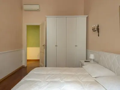 a bedroom with a white bed and a white cabinet at Apartment Plinio by Interhome in Rome
