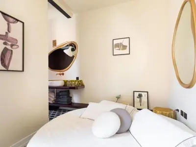 a bedroom with a white bed with a round mirror at Apartment La Dolce Vita by Interhome in Rome