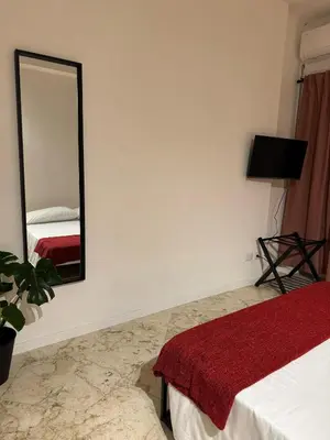 a bedroom with a mirror on the wall and a bed at Residenza Piramide in Rome