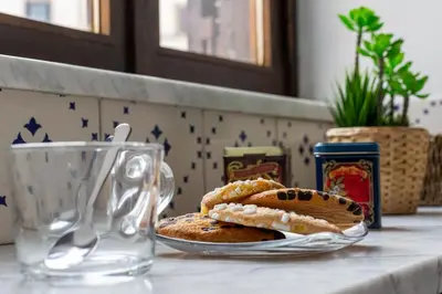 a plate of cookies on a table with a glass mug at iFlat A Vintage Gem Apartment near Piazza Navona in Rome