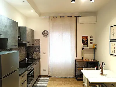 a kitchen with a refrigerator and a table in it at a pochi passi dalla Metro A e dal Vaticano - NUMA HOUSE in Rome