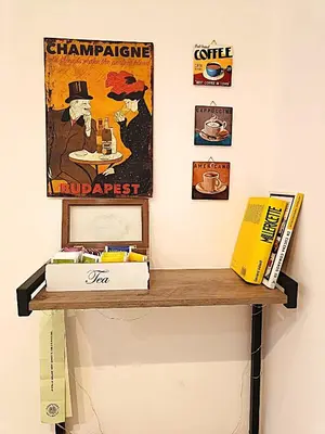 a shelf on a wall with posters and books at a pochi passi dalla Metro A e dal Vaticano - NUMA HOUSE in Rome