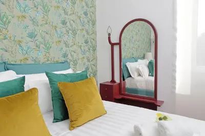 a bedroom with two beds and a mirror at Vatican 47 in Rome