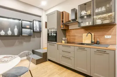 a kitchen with gray cabinets and a table and a sink at Appartamento My Happy Place Rome in Rome