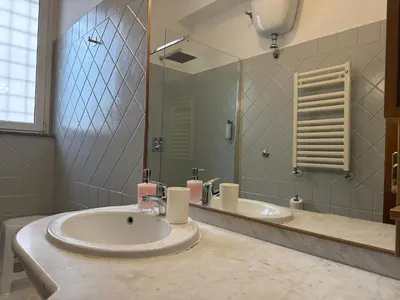 a bathroom with two sinks and a large mirror at Domi 10 Apartment, Stazione Termini, Via Curtatone 12 in Rome