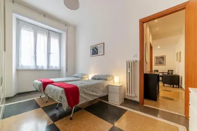 a bedroom with a bed with a red blanket on it at GuestHost - Piazza Bologna Apartment in Rome