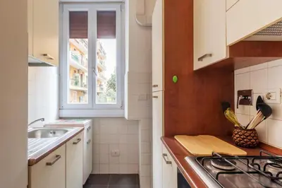 a kitchen with white cabinets and a sink and a window at GuestHost - Piazza Bologna Apartment in Rome