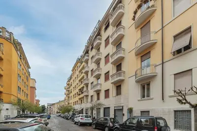 a street with cars parked next to a tall building at GuestHost - Piazza Bologna Apartment in Rome