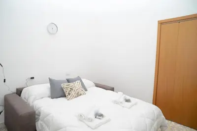 a bedroom with a bed with white sheets and pillows at Minimal e funzionale soggiorno vicino al Vaticano in Rome