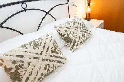 a white bed with two pillows on top of it at Minimal e funzionale soggiorno vicino al Vaticano in Rome