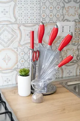 a vase with red handled utensils on a counter at Minimal e funzionale soggiorno vicino al Vaticano in Rome