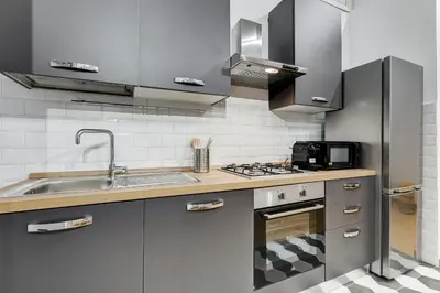 a kitchen with stainless steel appliances and a sink at 3-Bedroom Home Near Trastevere Station in Rome