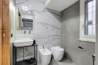 a bathroom with a white sink and a toilet at 3-Bedroom Home Near Trastevere Station in Rome