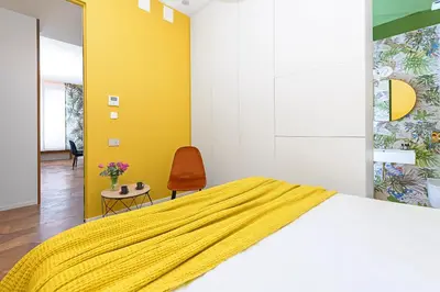 a bedroom with a bed and a yellow wall at Moon River Luxury Apartment in Rome