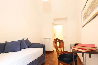 a living room with a white couch and a desk at Trastevere Essence by Nosdom Properties in Rome