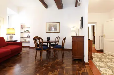 a living room with a table and a red couch at Trastevere Essence by Nosdom Properties in Rome