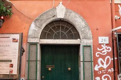 a green door on a building with a sign above it at Trastevere Rooftop Terrace Courtyard Loft in Rome