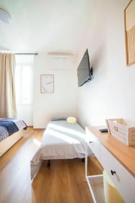 a bedroom with a bed and a desk with a monitor at Casa Stefano at the Vatican comfort in the Heart of Rome in Rome