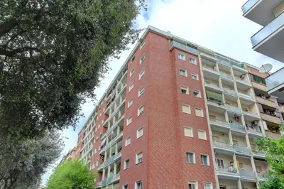 a red brick apartment building with a balcony at Marconi APT per Famiglie - 20 Min dal centro in Rome