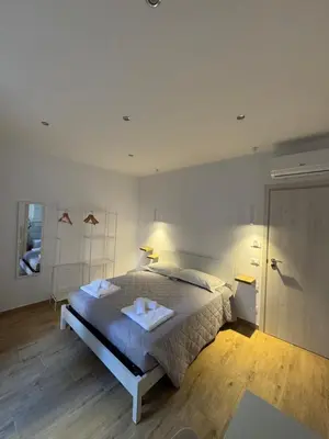 a bedroom with a large bed and a door at Suite Rooms Garbatella in Rome