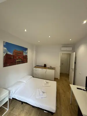 a bedroom with a white bed and a desk at Suite Rooms Garbatella in Rome