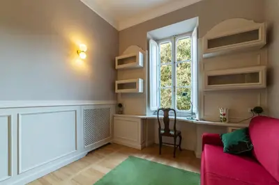 a living room with a red couch and a window at Santa Maria alle Fornaci - FromHometoRome in Rome