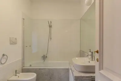 a bathroom with a tub and a toilet and a sink at Santa Maria alle Fornaci - FromHometoRome in Rome