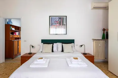 a bedroom with a large white bed with two towels at Casa Adele Lovely Mid-century Apartment, Rome in Rome