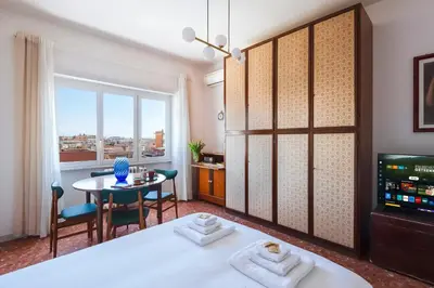 a bedroom with a bed and a table and a television at Casa Adele Lovely Mid-century Apartment, Rome in Rome