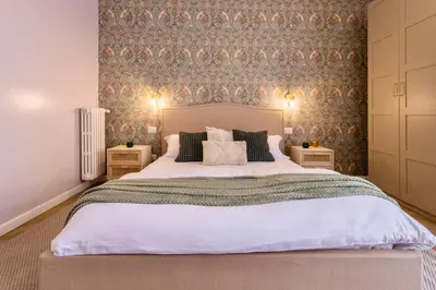 a bedroom with a large bed and a wall at Amelie - Gem of Trastevere in Rome