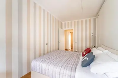a bedroom with a large bed with striped walls at Furio Family Flat, A Few Steps from Metro A Stop in Rome