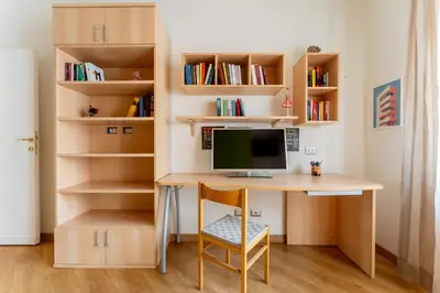 a home office with a desk and bookshelves at Furio Family Flat, A Few Steps from Metro A Stop in Rome
