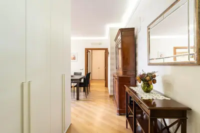 a hallway with a table with a vase of flowers on it at Furio Family Flat, A Few Steps from Metro A Stop in Rome