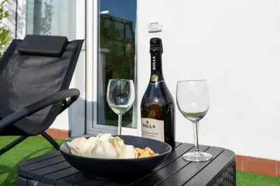 a bottle of wine and two glasses on a table at Domvs Tibvrtina - Solarium Zone, Terrace, A-C, Roma in Rome