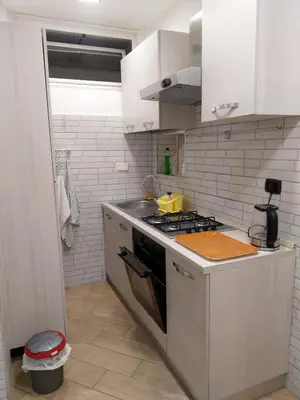 a kitchen with white cabinets and a stove top oven at Casa Carlo in Rome