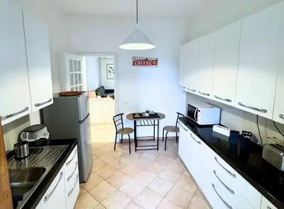 a kitchen with white cabinets and a table with chairs at Casa vacanze Roma Adelaide's house in Rome