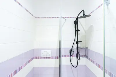 a shower in a bathroom with pink and white tiles at Grace's house Roma Trastevere in Rome