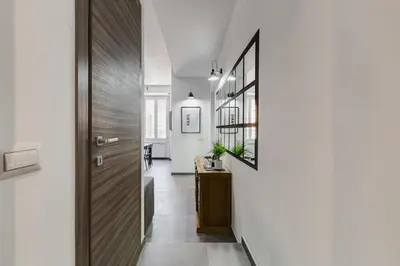 a hallway with a wooden door and a mirror at BDC - Majestic 4-Bdr in Termini in Rome