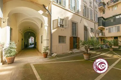 a building with a sign in the middle of a courtyard at La Torre Della Scimmia nido romantico a Piazza Navona in Rome