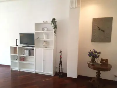 a living room with a tv and a white book shelf at Holiday apartment in Rome in Rome