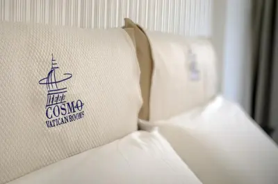 a pillow on a bed with a sign on it at Cosmo Vatican Rooms in Rome