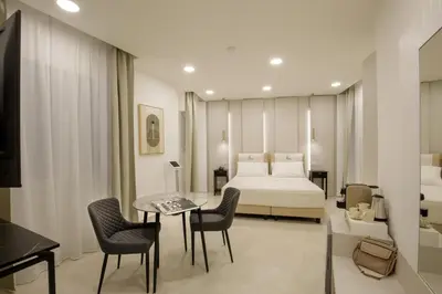 a hotel room with a bed and a table and chairs at Cosmo Vatican Rooms in Rome