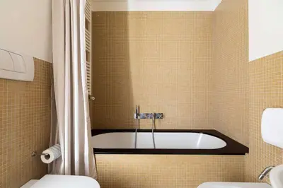 a bathroom with a tub and a toilet at Luce Trastevere Retreat by Romeloft in Rome