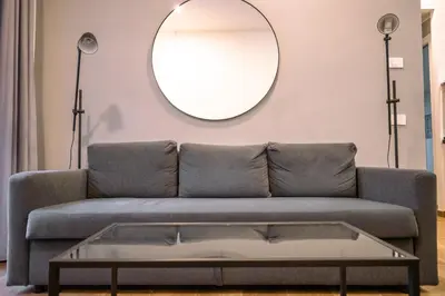 a living room with a couch and a mirror at Collection39 Doria Smart Apartment in Rome