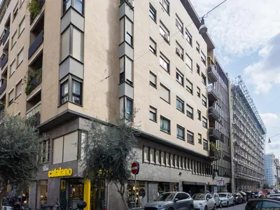 a tall building on a city street with parked cars at The Best Rent - Spacious Apartment Near Castel Sant’Angelo in Rome