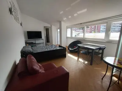 a living room with a bed and a table at Il Mulo Volante - Panoramico attico con terrazzo a Trastevere in Rome