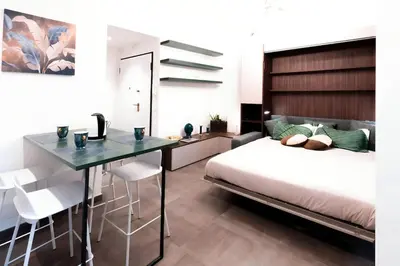 a bedroom with a bed and a table and chairs at 4 Min From Metro ''A'' Apt 15 Min from Colosseum in Rome
