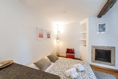 a white bedroom with a bed and a fireplace at Piazza Navona the most central apartment in Rome
