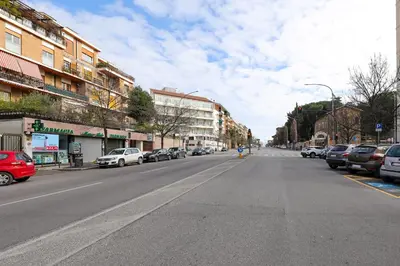 an empty city street with parked cars and buildings at Casa Cestia San Saba in Rome