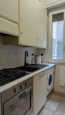 a kitchen with a stove and a washing machine at Casa vacanze Alle Mura Aureliane in Rome